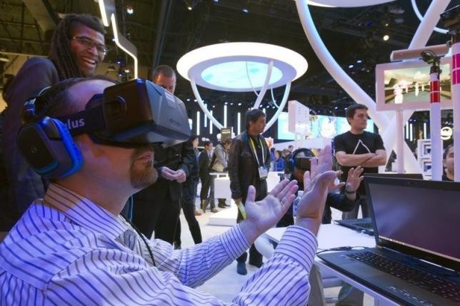 An attendee wearing an Oculus Rift virtual reality headset plays in a virtual volleyball game at the Intel booth during the 2015 International Consumer Electronics Show (CES) in Las Vegas, Nevada.