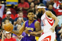 Los Angeles Lakers small forward Nick Young (L) drives past Houston Rockets' Corey Brewer.
