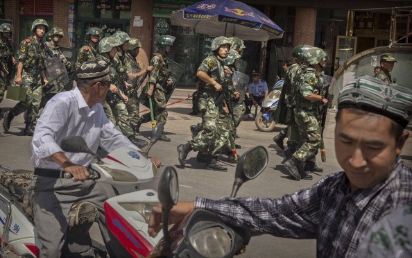 Chinese soldiers march past near the Id Kah Mosque, China's largest, in Kashgar, Xinjiang Uyghur Autonomous Region, on July 31, 2014.