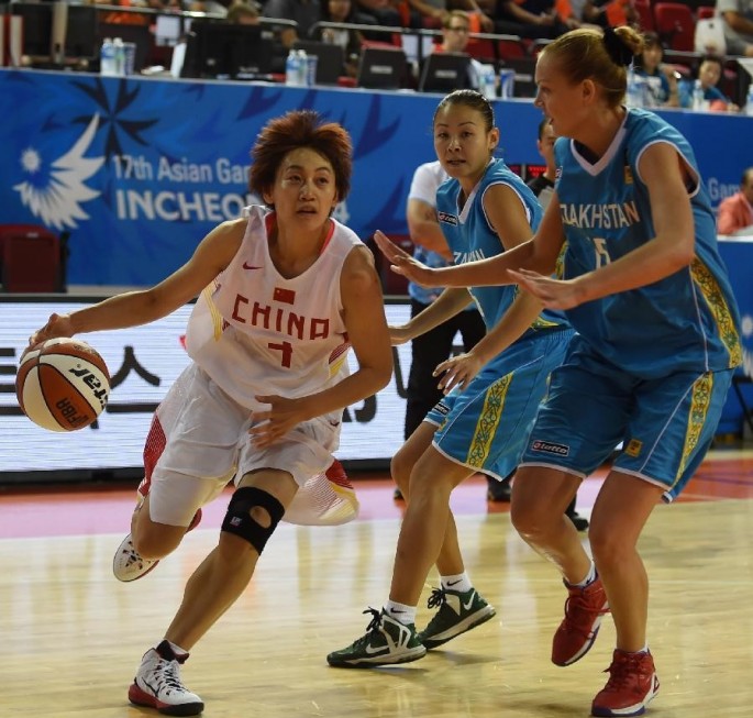Shanghai point guard Shi Xiufeng (L) playing for the China women's national basketball team.