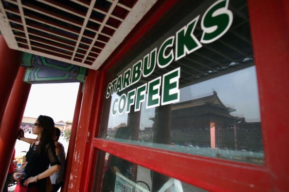 Visitors take a break at Starbucks Coffee at the Forbidden City on Sept. 6, 2005, in Beijing, China.