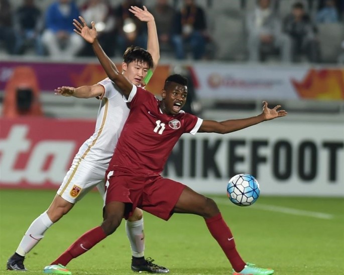 China's Wang Tong (L) competes with Qatar's Mohammed Muntari during their AFC U23 Championship Group A match.
