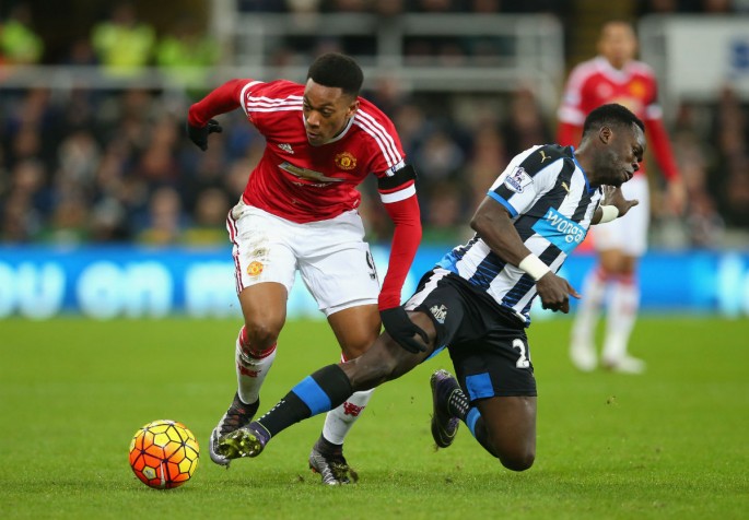 Newcastle United midfielder Cheick Tiote (R) competes for the ball against Manchester United's Anthony Martial.