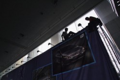 Workers install an exhibit area of Dongfeng Peugeot at the 2006 China International Automobile Science and Technology (S&T) Exhibition in Wuhan, Hubei Province, on May 26, 2006.