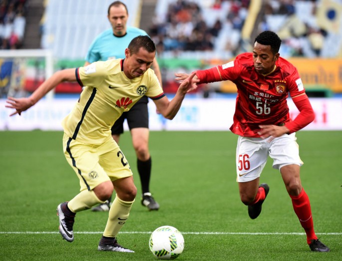 Former Guangzhou Evergrande forward Robinho (R) competes for the ball against Club America's Paolo Goltz.