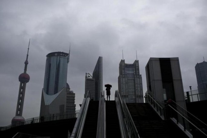 A woman holds an umbrella on an escalator in the financial district of Pudong, Shanghai, Nov. 25, 2014. 