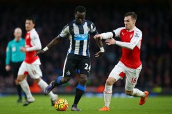 Newcastle United midfielder Cheick Tiote (middle) competes for the ball against Arsenal's Aaron Ramsey.