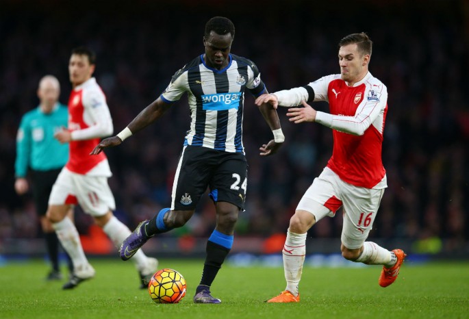 Newcastle United midfielder Cheick Tiote (middle) competes for the ball against Arsenal's Aaron Ramsey.