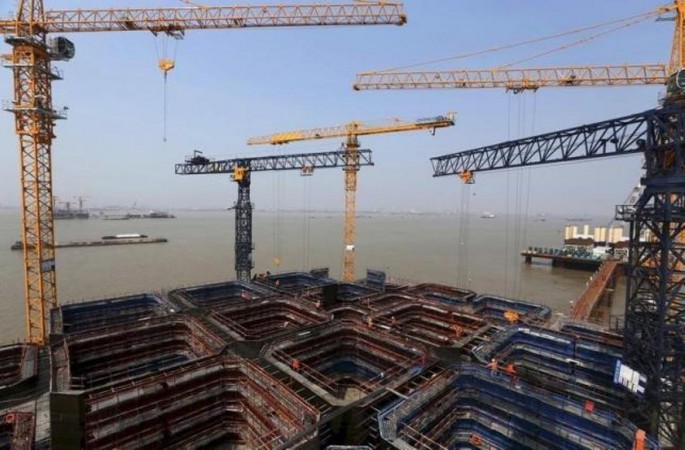 Cranes and workers are seen at a construction site at a main pier of the Hutong Yangtze River highway and railway bridge above the Yangtze River, in Nantong, Jiangsu Province, China, April 25, 2015.