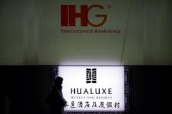 A woman walks past a hotel sign in Beijing where recently hotels received various awards in 