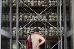 A tourist visits a memorial stupa made with the skulls of over 8,000 victims of the Khmer Rouge regime at Choeung Ek, on the outskirts of Phnom Penh. Aug. 4, 2014. 