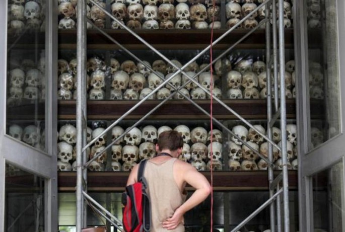 A tourist visits a memorial stupa made with the skulls of over 8,000 victims of the Khmer Rouge regime at Choeung Ek, on the outskirts of Phnom Penh. Aug. 4, 2014. 