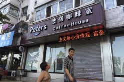 A man walks past the coffee shop owned by Canadians Kevin and Julia Garrett in Dandong in Liaoning Province. Kevin Garrett was indicted by Dandong court of espionage while Julia was released on bail.