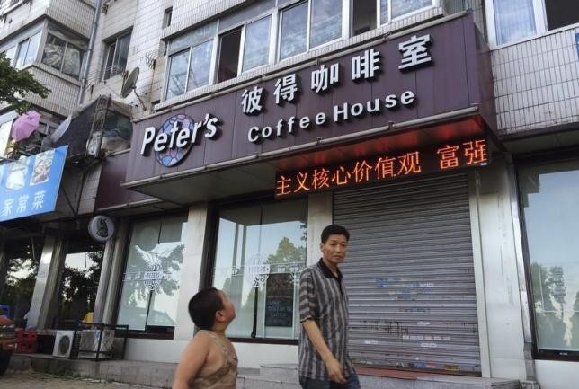 A man walks past the coffee shop owned by Canadians Kevin and Julia Garrett in Dandong in Liaoning Province. Kevin Garrett was indicted by Dandong court of espionage while Julia was released on bail.