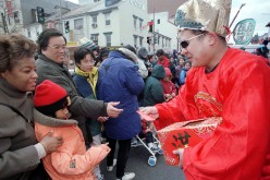 A man in a traditional Treasury God costume hands out red packets, the lucky money, at the annual Chinese New Year Parade in the Chinatown, Washington, D.C., on Feb. 21, 1999.