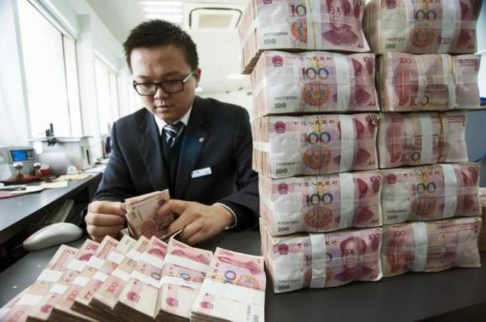 A clerk counts Chinese 100 yuan banknotes at a branch of China Construction Bank in Nantong, Jiangsu Province, Dec. 2, 2014.