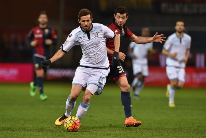 Lazio midfielder Senad Lulić (L) competes for the ball against Genoa's Blerin Dzemaili.