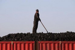 A worker loads coal on a truck at a depot near a coal mine from the state-owned Longmay Group on the outskirts of Jixi, Heilongjiang Province, China, Oct. 24, 2015.