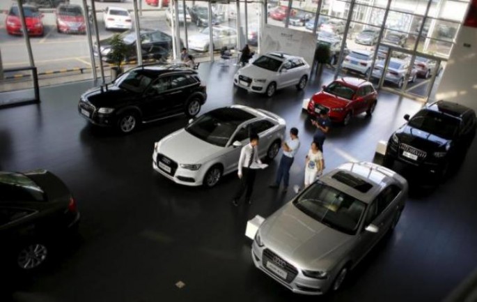 Prospective buyers look at cars displayed at a dealership in China, where auto financing firms have reported growth last year despite sluggish sales.
