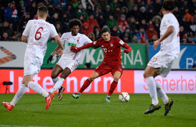Bayern Munich striker Robert Lewandowski goes against three Augsburg defenders.