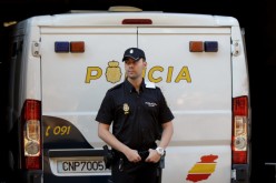  A policeman stands guard at a police van in Madrid, Spain, on Sept. 1, 2014. 