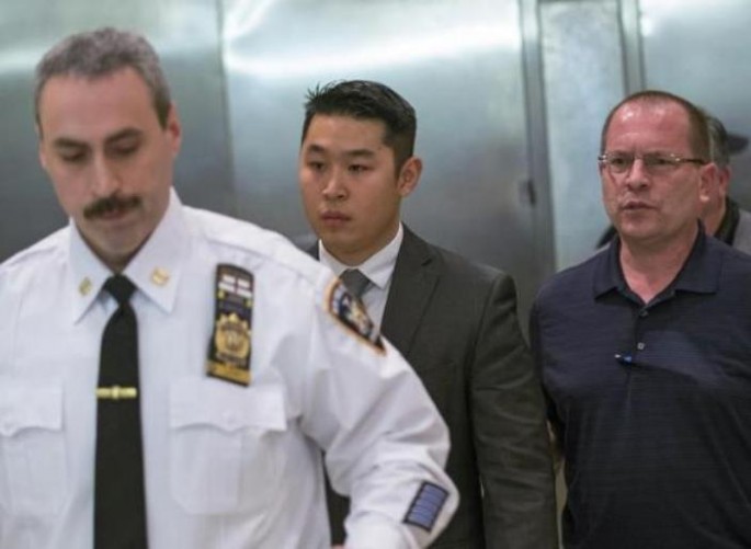 New York City Police (NYPD) officer Peter Liang (C) leaves the courtroom after an arraignment hearing in the Brooklyn borough of New York City on Feb. 11. 