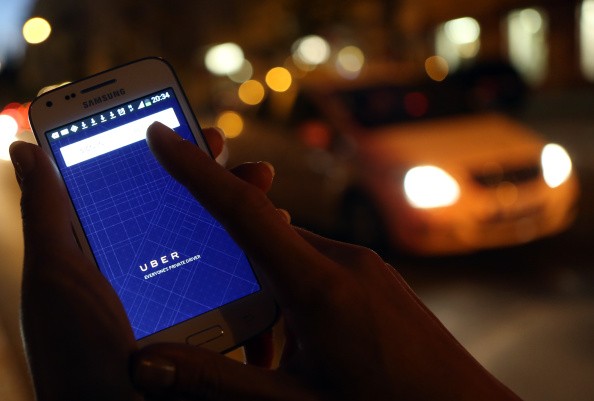 A woman uses the Uber app on a Samsung smartphone in Berlin, Germany, on Sept. 2, 2014.