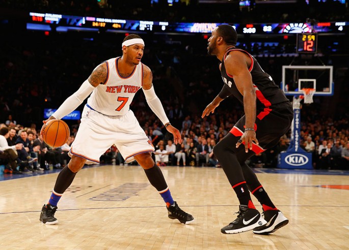 New York Knicks forward Carmelo Anthony (L) makes a move against Toronto Raptors Patrick Patterson.