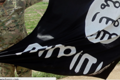 An ISIS activist displaying a flag of the terrorist organization.