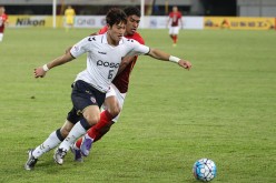 Kim Junsu of Pohang Steelers in action against Paulinho of Guangzhou Evergrande during the AFC Champions League match at Guangzhou Tianhe Sport Center in Guangzhou, China, on Feb. 24, 2016.