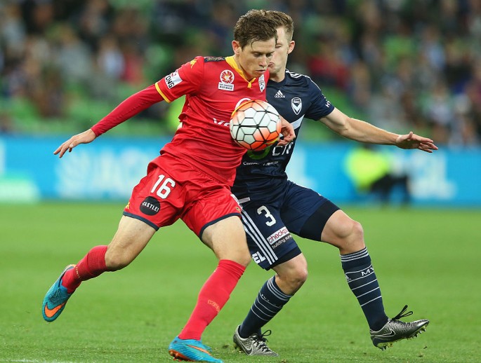 Adelaide United winger Craig Goodwin competes for the ball against a Melbourne Victory defender.