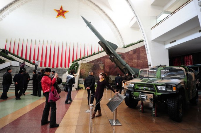 Visitors snap photos beside military hardware at the Military Museum as a Chinese-made Hongqi-2 surface-to-air missile stands on display in the background in Beijing. 