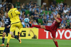 Shanghai SIPG striker Elkeson (R) tries to score past Melbourne Victory goalkeeper Danny Vukovic during their Champions League group stage match.