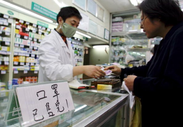 A pharmacy employee attends to a customer in downtown Shanghai, China, on April 25, 2003.