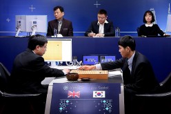 South Korean pro Go player Lee Se-dol (R) puts his first stone against Google's AI AlphaGo during the Google DeepMind Challenge Match in Seoul, South Korea, on March 10, 2016.