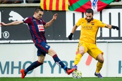 Eibar midfielder Gonzalo Escalante competes for the ball against Barcelona's Arda Turan.