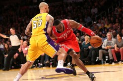 Houston Rockets center Dwight Howard (R) drives against LA Lakers' Robert Sacre.