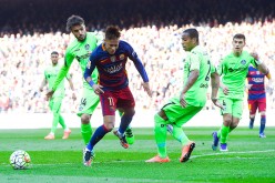 Barcelona winger Neymar (C) competes for the ball against two Getafe CF players.