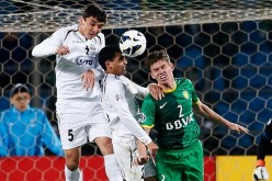 Uzbekistan national team and Beijing Guoan defender Egor Krimets (C) competes for the ball against two Bunyodkor players.