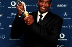 US basketball legend Dikembe Mutombo poses with his award for 'Sport For Good ' in the Awards room.