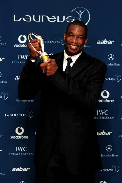 US basketball legend Dikembe Mutombo poses with his award for 'Sport For Good ' in the Awards room.