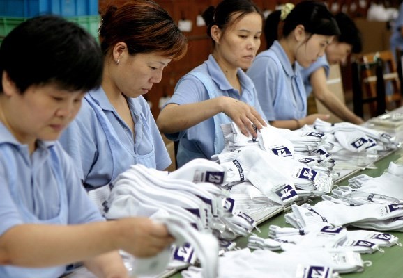 Workers prepare socks at a facility in Shanghai. China's manufacturing sector is being hit hard by the country's aging population.
