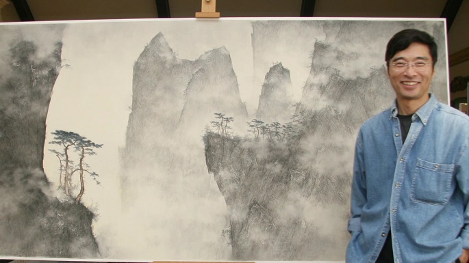 Behind every great artist is a great piece of art, in the literal sense of the word, as shown in the picture: Li Huayi posing with one of his creations.