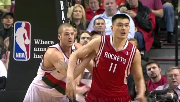 NBA Playoffs 2009 First Round: Yao Ming waits to receive the ball. Close behind to thwart him is the 7-foot-1 Joel Przybilla playing for Portland Trail Blazers.