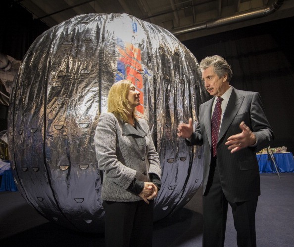 NASA Deputy Administrator Lori Garver and President and founder of Bigelow Aerospace Robert T. Bigelow talk while standing next to the Bigelow Expandable Activity Module (BEAM) during a media briefing.