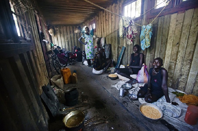 Grains of hope: China gives rice to South Sudan. (Above) Displaced women and children gather inside a container in a compound in Bentiu.