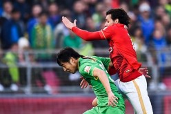 Guangzhou Evergrande midfielder Ricardo Goulart (R) competes against Beijing Guoan's Zhao Hejing.