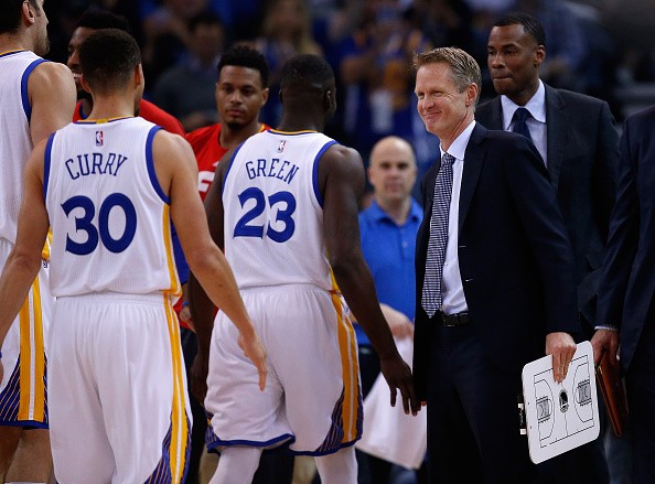 Warriors head coach Steve Kerr congratulates Draymond Green and Stephen Curry during a time out of their game against the Indiana Pacers.