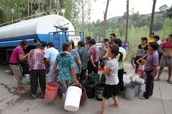 Villagers crowd around to receive water in Luoyang, Henan Province, on Aug. 4, 2014.