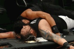 Roman reigns and  Bray Wyatt lay on the ruins of a table during a WWE hell-in-a-cell match in 2015.